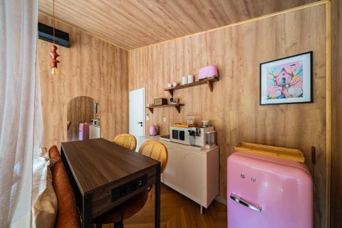 a small kitchen with a table and a pink refrigerator at Nowoczesne Domki na Drzewie - Kołobrzeg - Sauna - PolanaGlamp in Nieżyn