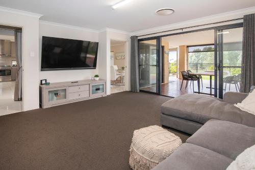 a living room with a couch and a flat screen tv at 13th Tee by the Sea- On the Golf Course in Dunsborough