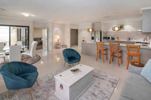 a living room and kitchen with a couch and chairs at 13th Tee by the Sea- On the Golf Course in Dunsborough
