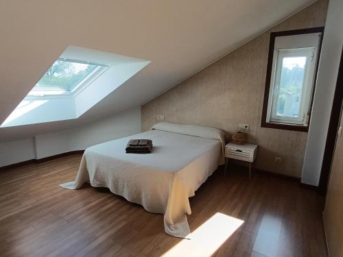 a bedroom with a bed and a skylight at Apartamento Rio Gallo II in Cuntis