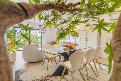 a dining room with a glass table and white chairs at Nora Charming Apartment - Pool -10m Walk City Center in Funchal