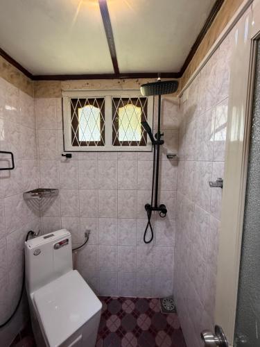 a bathroom with a toilet and a window and a shower at RUU Holiday Home in Nuwara Eliya
