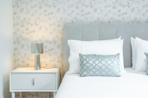 a bedroom with two beds with white pillows and a night stand at Nora Charming Apartment - Pool -10m Walk City Center in Funchal