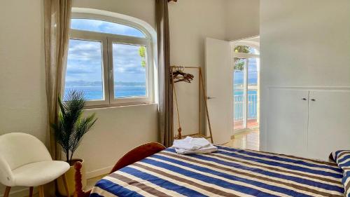 1 dormitorio con cama de rayas azul y blanco y ventana en Villa Narcol, en L'Estartit