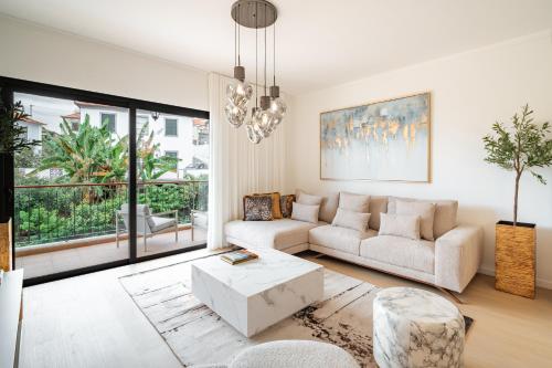 a living room with a couch and a table at Nora Charming Apartment - Pool -10m Walk City Center in Funchal
