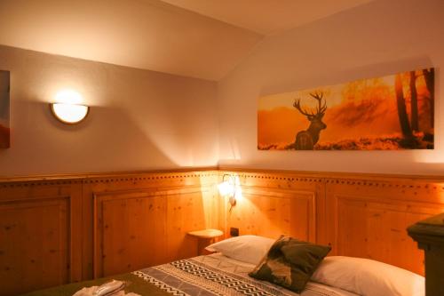 a bedroom with a bed and a picture of a deer on the wall at Shackleton Chalet in Sestriere