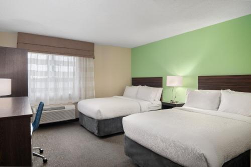 a hotel room with two beds and a desk at Garner Hotel Londonderry - Manchester by IHG in Londonderry
