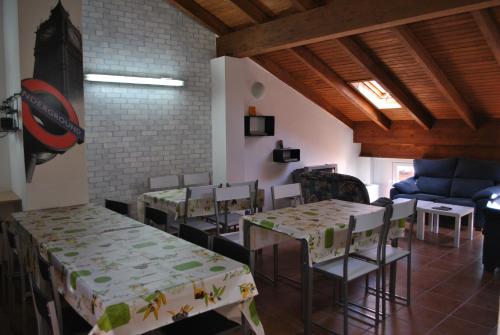 a dining room with tables and chairs and a couch at Hostal la Catedral in Santo Domingo de la Calzada