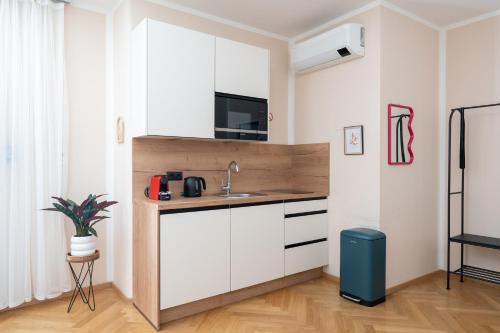 a kitchen with white cabinets and a sink at Vienna Stay Apartments Schönbrunn in Vienna