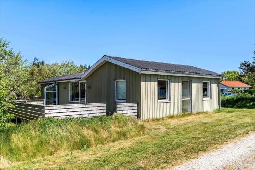 a small house on a grassy field next to a road at 149-Snedsted-Lykkens-Hab-39 in Snedsted