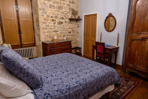 a bedroom with a bed and a table and a desk at Les Petits Cousins Du Québec - Chambres D’hôtes à Domme in Domme