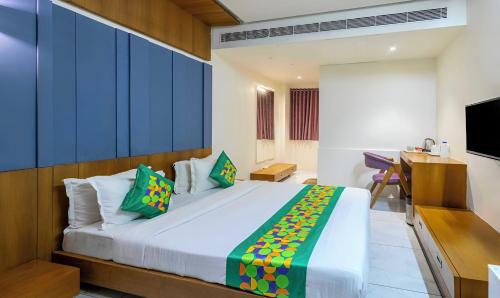 a bedroom with a large bed and a desk at Kasa Hotels in Gandhinagar