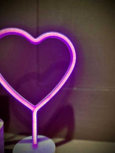 a purple heart shaped lamp sitting on a table at Red Velvet-Romantik Appartement mit Balkon & Flussblick - Das Alpenzeit im Zentrum mit Parkplatz in Bad Aussee
