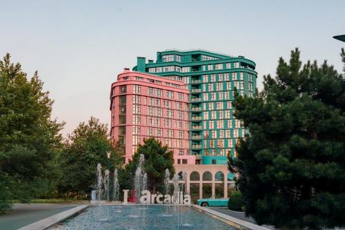 a tall red building with a fountain in front of a building at Archotel Avenue in Odesa
