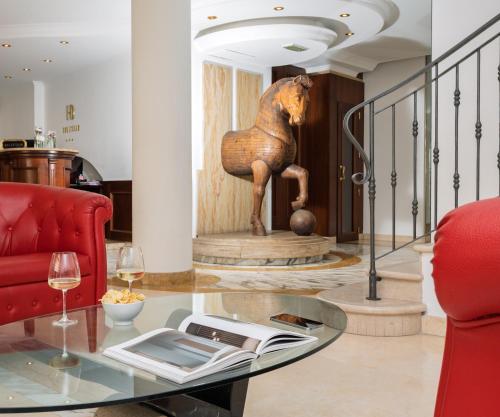 a room with a glass table with a horse statue at Hotel Donatello in Padova