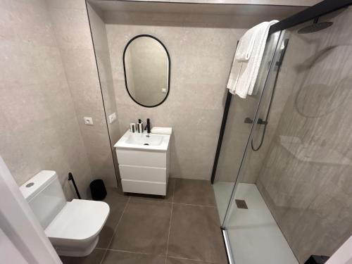 a white bathroom with a sink and a mirror at VI Apartamento dos dormitorios junto a Plaza Mayor in Salamanca