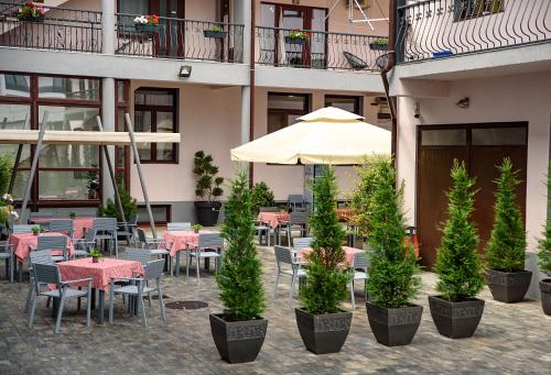 a restaurant with tables and chairs and an umbrella at Hotel Stefani in Sibiu