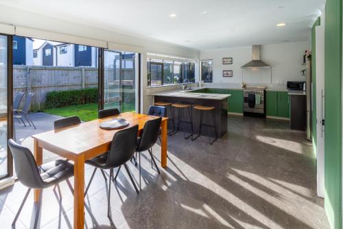 a kitchen with green cabinets and a wooden table and chairs at Urban Nest on Perth 3BR 1 and a half Bath Free Parking in Christchurch