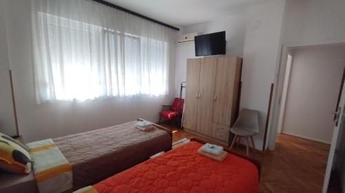 a small bedroom with two beds and a window at NANA apartment in Ohrid