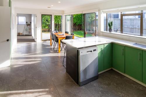 a kitchen with green cabinets and a table with chairs at Urban Nest on Perth 3BR 1 and a half Bath Free Parking in Christchurch