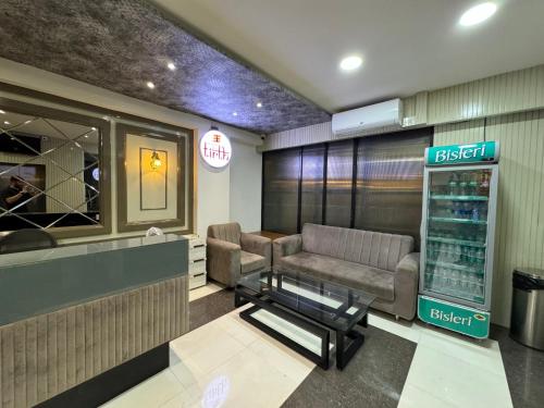 a waiting room with a couch and a chair at Col's Hotel Uphaar Tirth in Ujjain