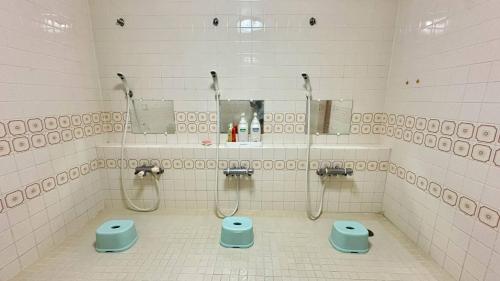 a bathroom with two showers and two toilets in it at ふる郷荘Furusato Furano in Furano