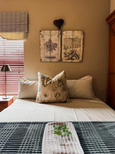 a bedroom with a bed and two paintings on the wall at The Urn Guesthouse in Middelburg