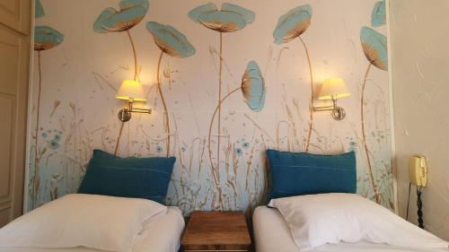 a bedroom with two beds and a wall with flowers at Bergerie du Château - Lacapelle Marival in Lacapelle-Marival