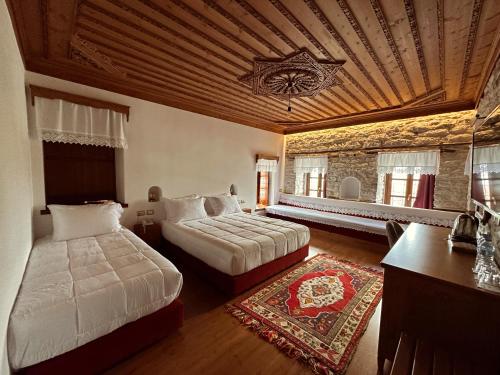 a large bedroom with two beds and a table at Kalemi Twin Boutique Hotel in Gjirokastër