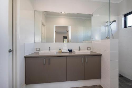 a bathroom with two sinks and a mirror at Tidal Wave Hideaway in Broadwater