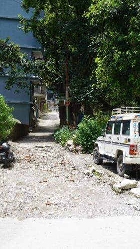 a white jeep parked next to a house at Hari Om Guest House in Narendranagar