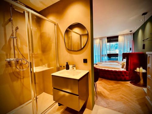 a bathroom with a shower and a sink and a mirror at Red Velvet-Romantik Appartement mit Balkon & Flussblick - Das Alpenzeit im Zentrum mit Parkplatz in Bad Aussee