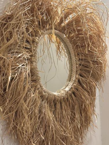 a wreath made out of dry grass and a mirror at Casa Palma Boutique Hotel in Vlorë
