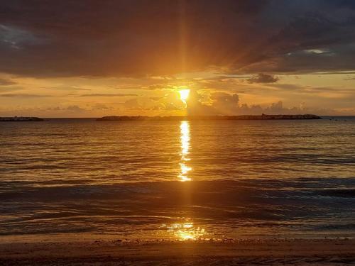 a sunset on the beach with the sun setting at Casa al mare Teresa in Porto SantʼElpidio