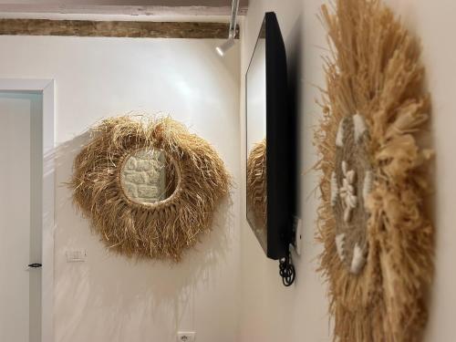 a wall with a mirror and some hay on a wall at Casa Palma Boutique Hotel in Vlorë