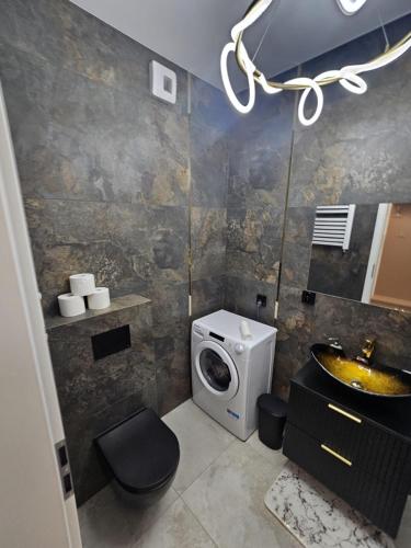 a bathroom with a sink and a washing machine at LUXURY APARTMENTS WILCZA 8 by Marta klimatyzacja in Radom