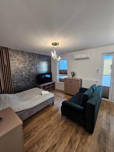 a bedroom with a bed and a couch in a room at LUXURY APARTMENTS WILCZA 8 by Marta klimatyzacja in Radom