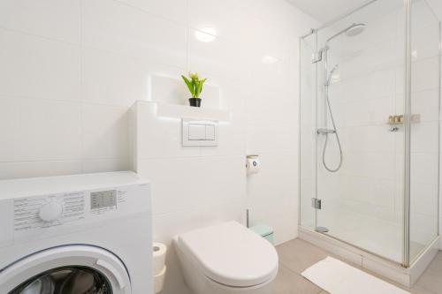 a white bathroom with a toilet and a shower at Vienna Stay Apartments Schönbrunn in Vienna