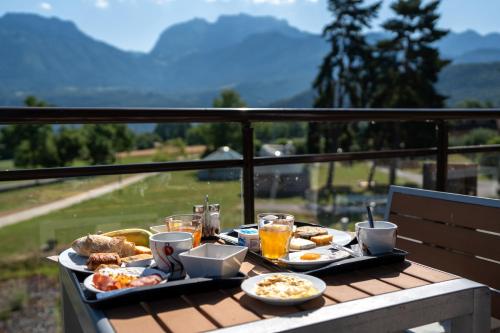 a table with food and drinks on a balcony at Le Pré du Lac in Saint-Jorioz