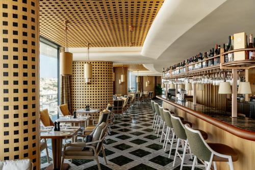 a restaurant with a bar with chairs and tables at ME Malta by Meliá in St Julian's