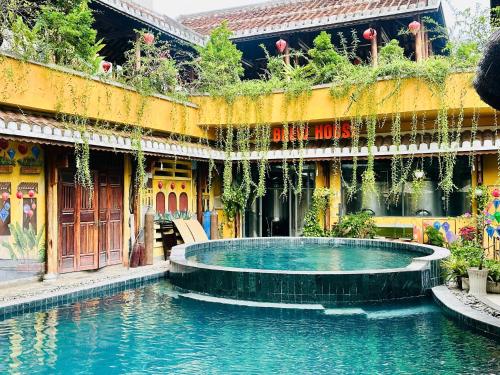 a swimming pool in front of a building with a fountain at MissBamboo Hotel Nha Trang in Nha Trang