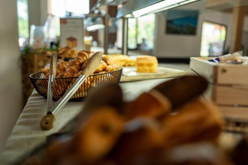 a table topped with baskets of bread and pastries at Le Pré du Lac in Saint-Jorioz