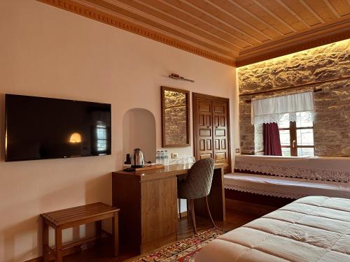 a bedroom with a bed and a desk and a television at Kalemi Twin Boutique Hotel in Gjirokastër