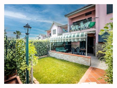 a house with a patio and a balcony with a yard at Casetta mia Seaside in Buonfornello