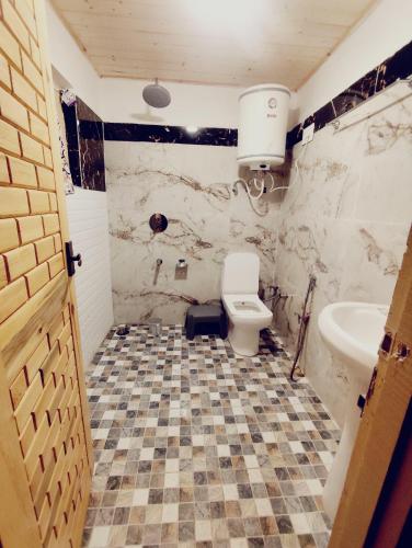 a bathroom with a toilet and a sink at Birdsong 5BR Stay with Riverside by Homeyhuts in Pahalgām