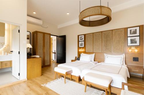 a bedroom with two beds and a table at 98 Acres Resort & Spa in Ella