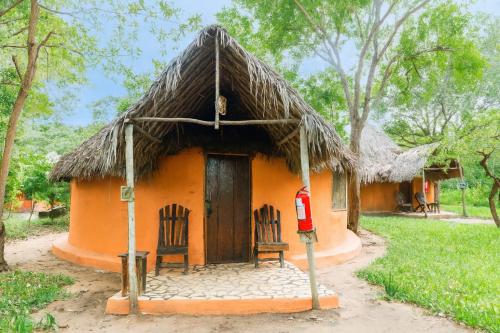 a small house with chairs and a thatch roof at Africa Safari Selous Nyerere national park in Nyakisiku