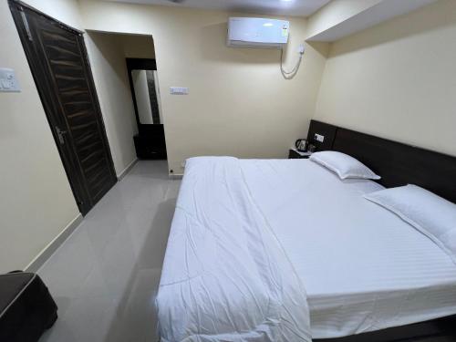 a bedroom with a large white bed in a room at Hotel Akaash in Jamshedpur
