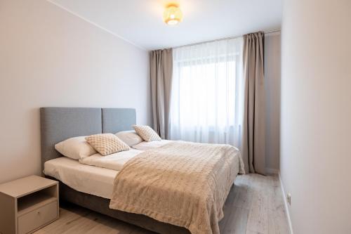 a bedroom with a bed and a large window at Apartamenty Rondo in Świnoujście