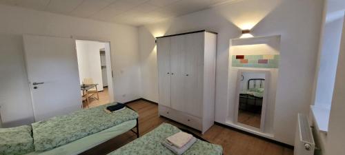 a room with two beds and a cabinet at Seyfarthrooms - Monteurwohnung Großröhrsdorf 4 - zentrale Lage, gute Anbindung, ideal für 2 Personen in Großröhrsdorf
